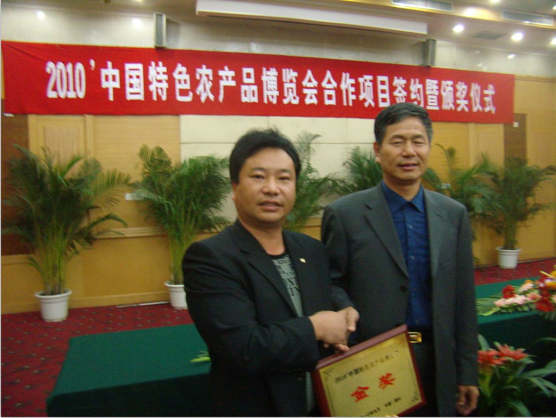中国食用菌协会常务副会长陆解人(右一)给亿昌菌业张东平总经理颁奖